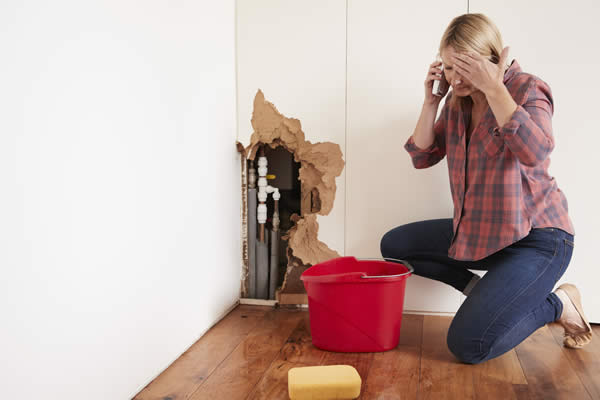 Woman sponging up water leak